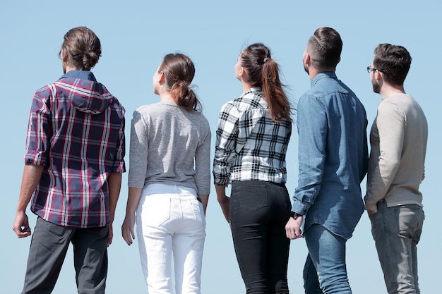 Foto vista posteriore un gruppo di giovani che guardano lo spazio della copia