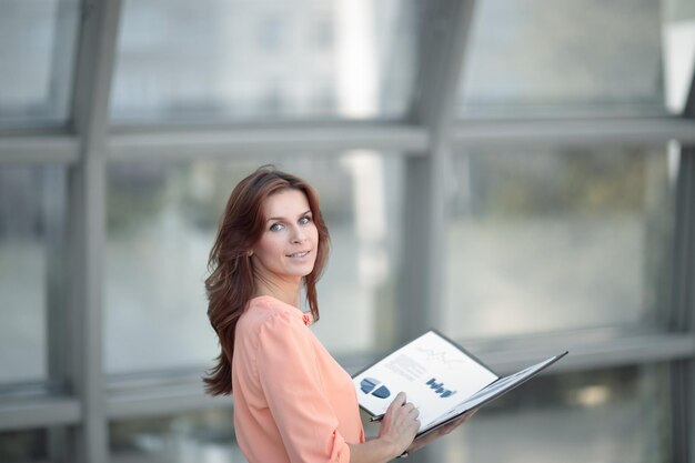 Rear viewa young business woman holds a folder with financial documents