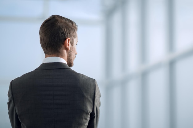 Rear viewbusinessman standing near the office window