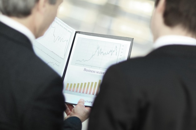 Rear viewcloseup of business partners discussing financial documents