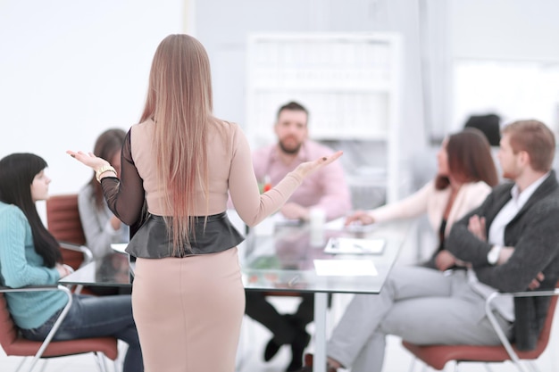 Rear viewimage of a business woman at a briefing with a business team