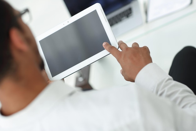 Rear viewmodern man uses a digital tablet