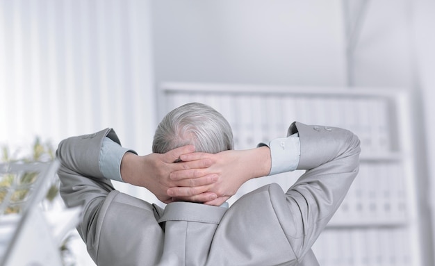 Rear viewsenior businessman dreaming of sitting at his Desk