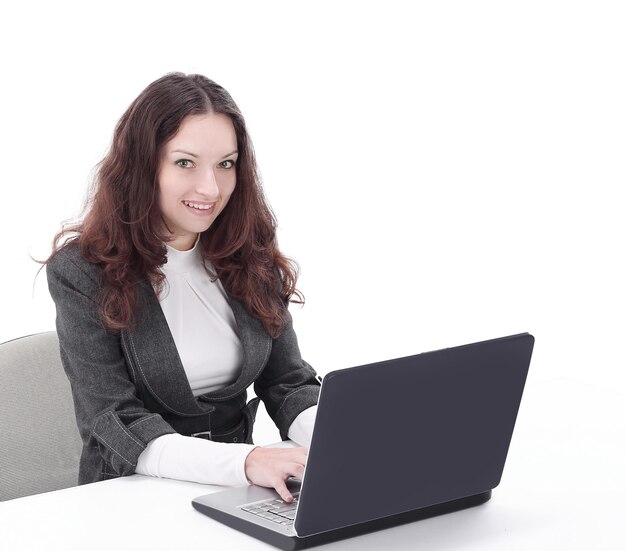 Rear viewsmiling businesswoman typing on laptop and looking at