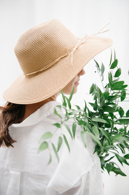 Photo rearview of a brown hair woman in a woven hat