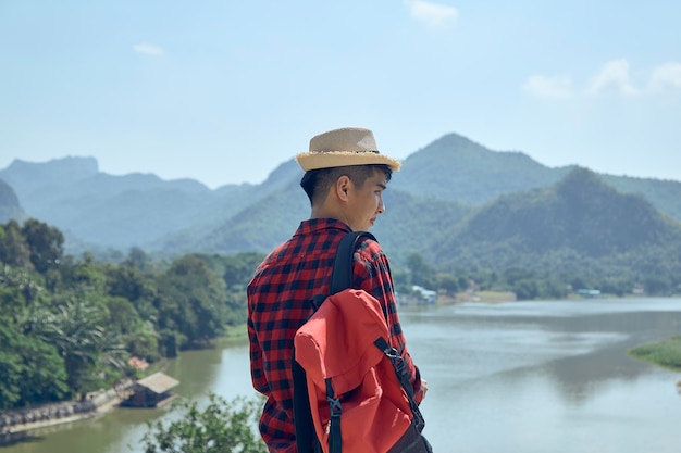 서있는 남성 관광객의 뒷모습은 산과 강을 바라보고 있습니다.