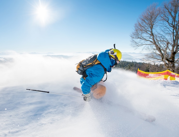 Foto rearview schot van een freerider skiër die onderaan de helling bij skitoevluchtbergen glijdt