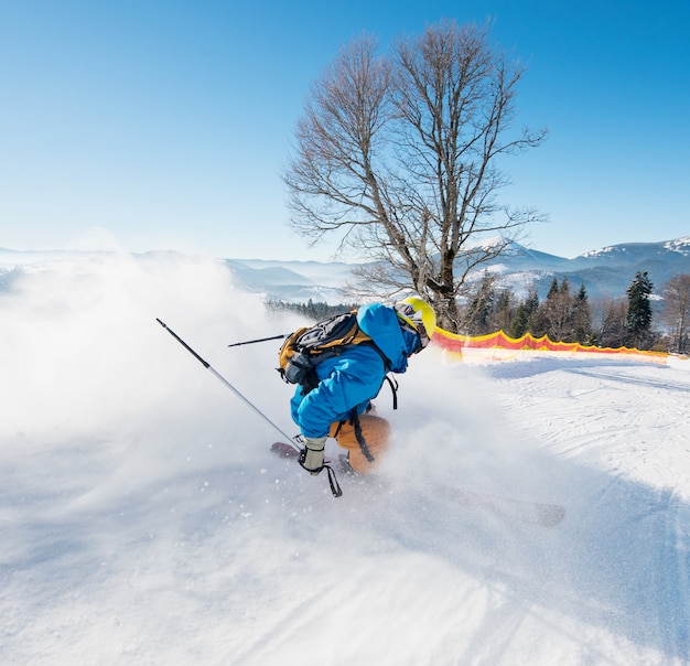 Rearview shot of a skier riding down the slope at ski resort in\
the carpathians mountains seasonal activity sport sportsman hobby\
recreation travel concept