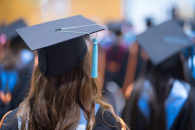 Foto retrovisore dei laureati in fila per il premio di laurea nella cerimonia di laurea universitaria. i laureati si stanno radunando alla cerimonia di laurea. folla dei laureati.