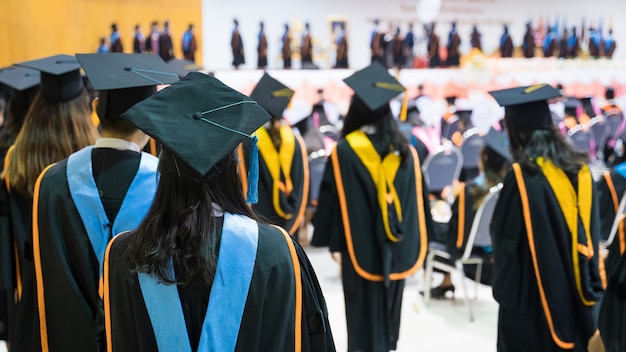 Rearview of the university graduates line up for degree award\
in university graduation ceremony. the university graduates are\
gathering in the university graduation ceremony. crowd of the\
graduates.