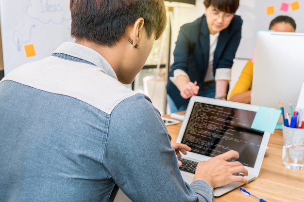 Reaw view of businessman using the computer over the couple Of Asian