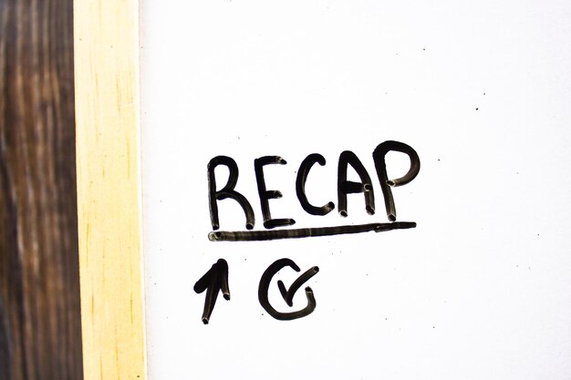 RECAP text concept on white board with check and arrow