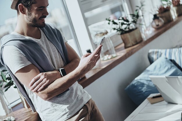 receiving funny messages. handsome young man holding smart phone 