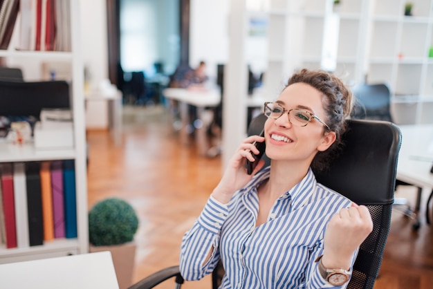 Ricevere buone notizie economiche. bella giovane donna parlando al telefono cellulare