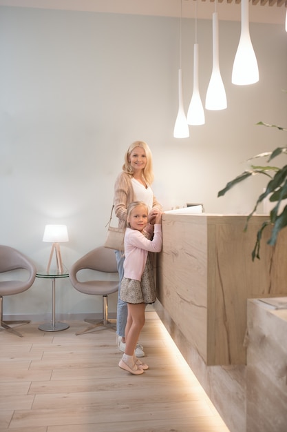 At the reception. A blonde woman and her daughter waiting for the appointment at the clinic