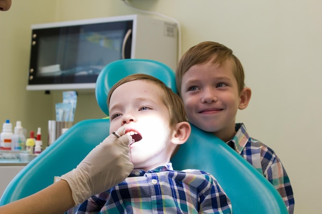 Reception at the dentistry a little boy lays on the couch and his brother stays behind