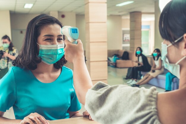 Receptionist and guest wearing face mask at front desk .