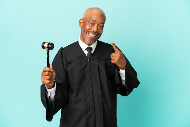 Rechter senior man geïsoleerd op blauwe achtergrond met een duim omhoog gebaar