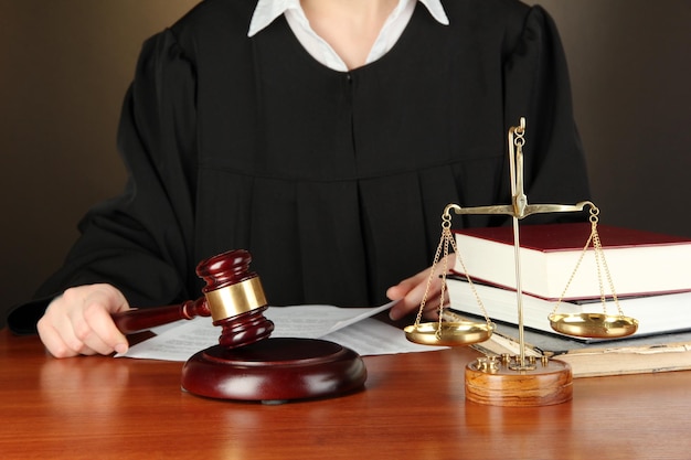 Rechter zit aan tafel tijdens rechtszittingen op een zwarte achtergrond