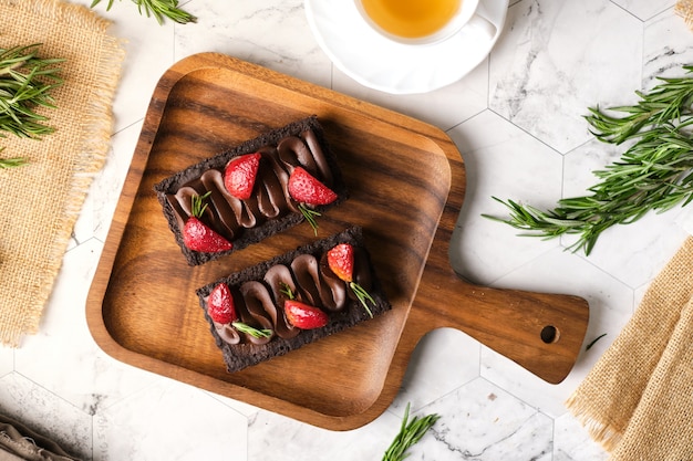 Foto rechthoekige chocoladetaart met aardbei in cafétafel