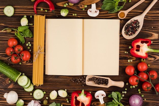 Photo a recipe book is opened on a wooden table, with ingredients for italian dishes laid out