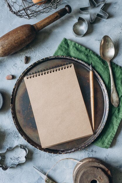 Recipe book mockup on kitchen table with kitchen utensils in\
vintage style