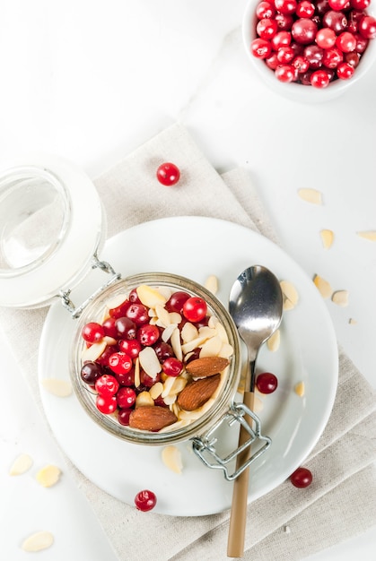 Ricetta per una sana colazione invernale, idee per la mattina di natale. farina d'avena durante la notte con mandorle, mirtilli rossi, zucchero. . vista dall'alto di copyspace