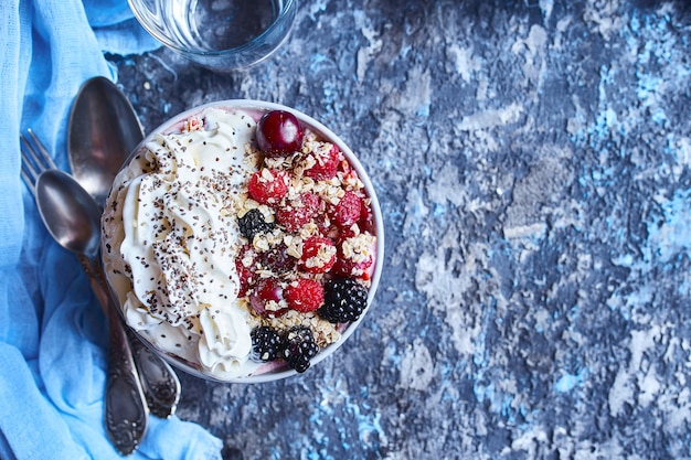 Recipe ideas for summer diet breakfast, healthy morning dessert in portioned soup plate with summer berries - raspberry, cherries, blackberry. 