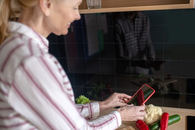 Photo recipes online. woman standing in the kitchen and looking for recipes online