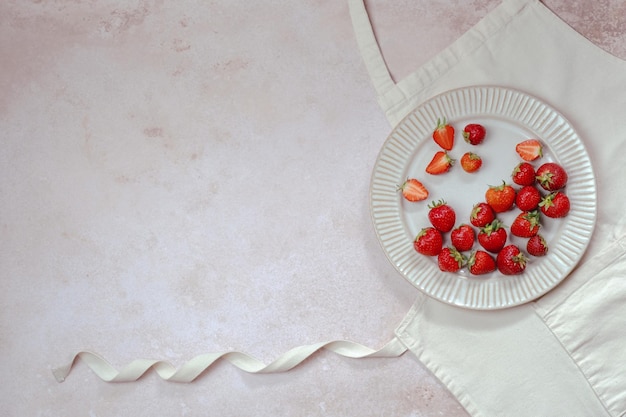 Recipes for summer holiday baking Strawberries in a plate on a mockup apron text background