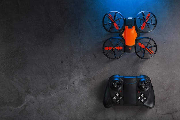 A reconnaissance quadcopter drone with an orange body a