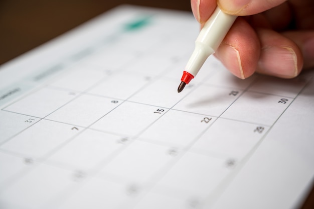 Recording his schedule on a desktop calendar.