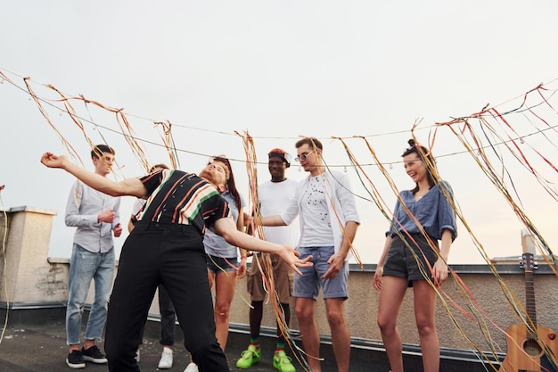 Recreatietijd Groep jongeren in vrijetijdskleding hebben overdag samen een feestje op het dak