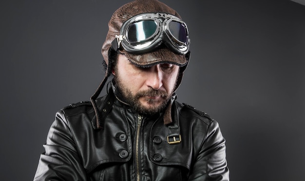 Photo recreation of the second world war, old airplane pilot with brown leather jacket, cap of avidor and large glasses