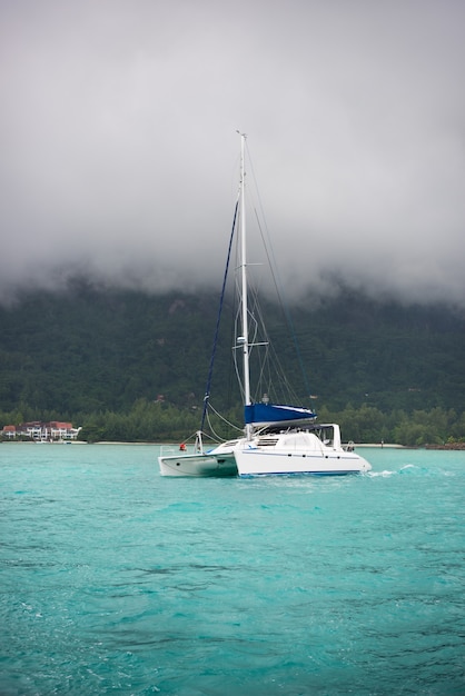 Recreational Yacht in fog at the coast of Seychelles.