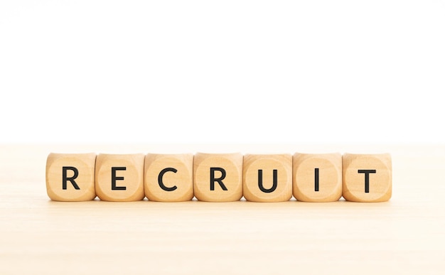 Recruit word on wooden blocks on white background Copy space