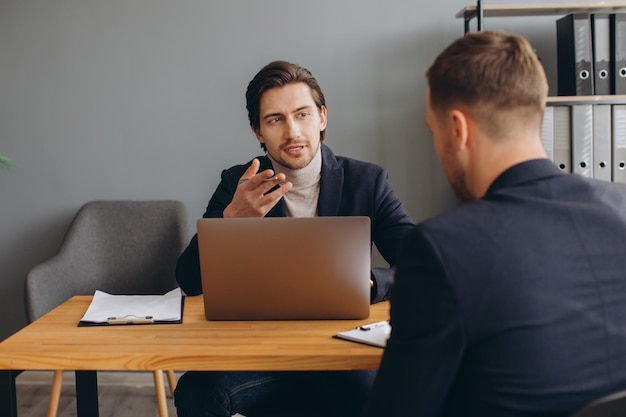 Recruiter tijdens zakelijk sollicitatiegesprek op kantoor met mannelijke kandidaat