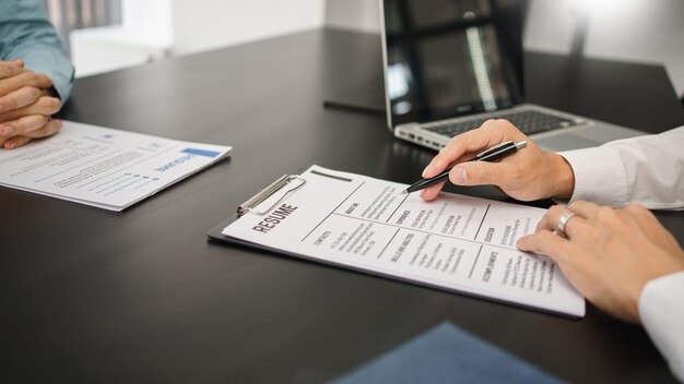 Recruitment concept Male employer reading resume of applicant during job interview