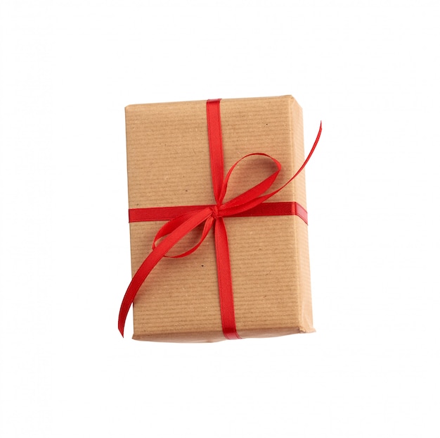 Rectangular box wrapped in brown paper and tied with a red bow isolated