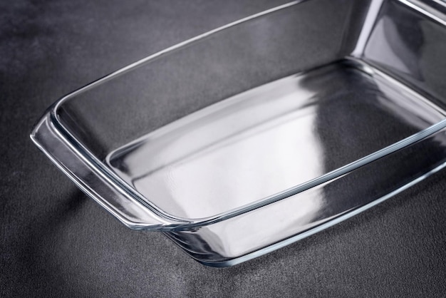 A rectangular glass empty dish for baking on a dark concrete background Preparation for baking tasty cupcake