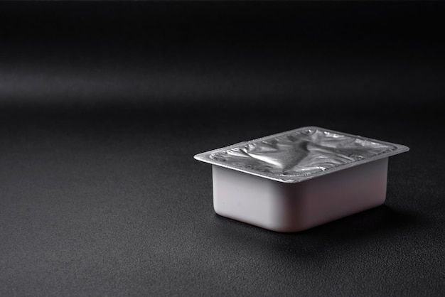 Rectangular plastic box with yogurt or cheese hermetically sealed with a foil lid