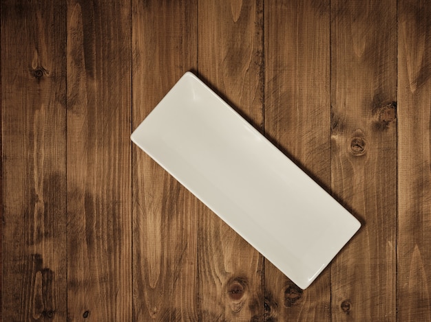Photo rectangular plate on a wooden table - top view