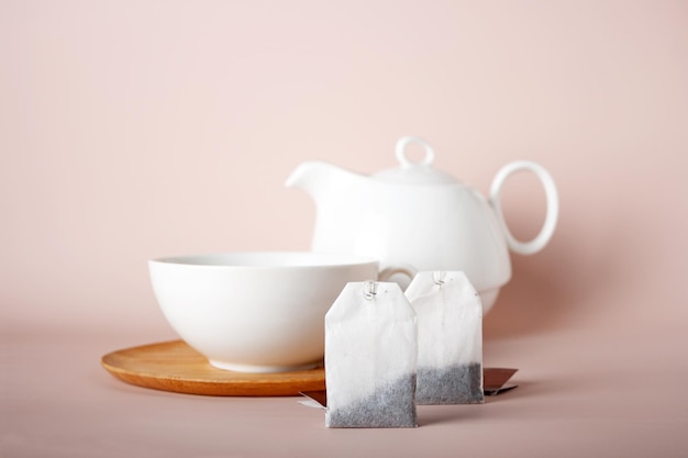 Rectangular tea bags on the background of ceramic cups and teapot copy space selective focus