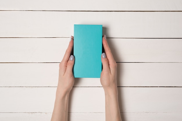 Photo rectangular turquoise box in female hands.