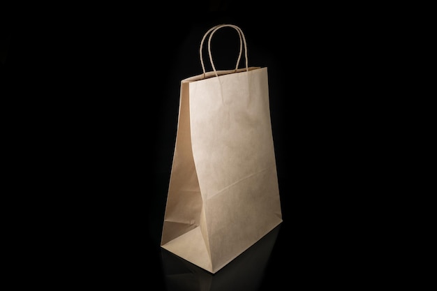 Recyclable craft paper bag for purchases gifts and takeaway food mock up on black background Environmentally friendly than singleuse plastic bags