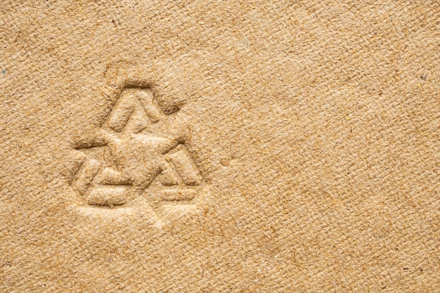 Recycle sign on brown cardboard paper texture background