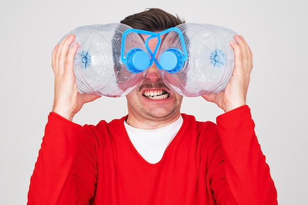 Recycle waste management concept Man hiding behind an empty water bottle