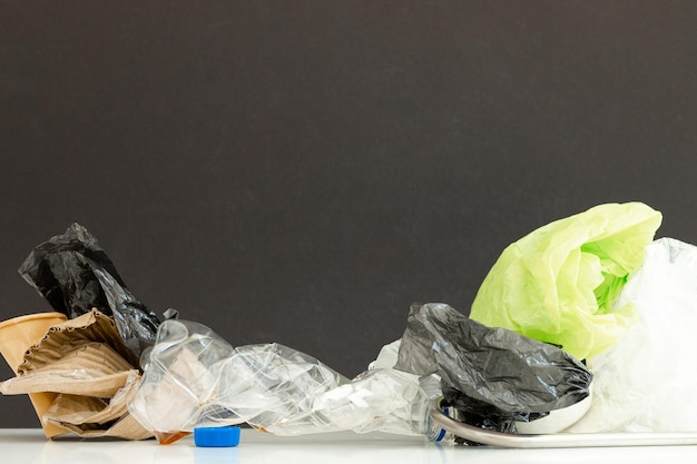 Recyclebaar afval bestaande uit glas kunststof metaal en papier op zwart