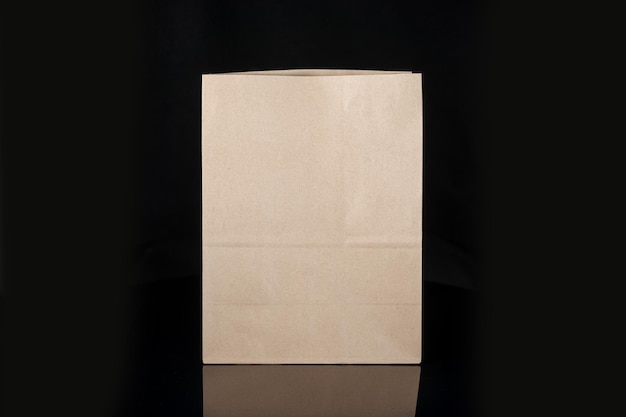 Recyclebare ambachtelijke papieren zak voor aankopen, geschenken en afhaalmaaltijden mock-up op zwarte achtergrond Milieuvriendelijker dan plastic zakken voor eenmalig gebruik