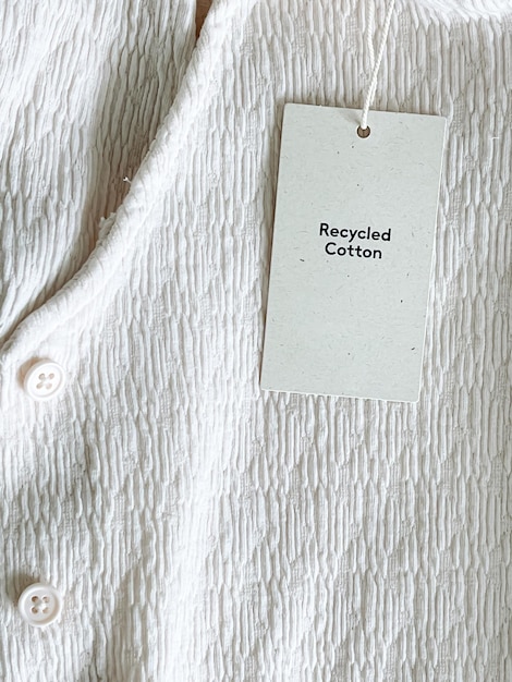 Recycled cotton fashion label tag sale price card on luxury fabric background shopping and retail